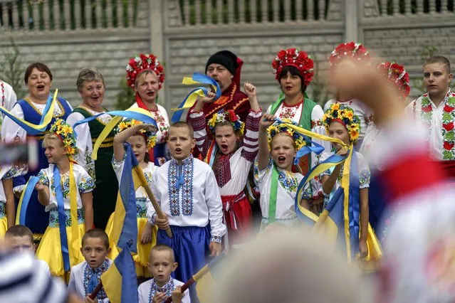 Members of a local community center wear traditional Ukrainian clothing to record an online video message for the country's upcoming Independence Day on Aug. 24 in Andriivka, Donetsk region, eastern Ukraine, Friday, August 19, 2022. (Photo by David Goldman/AP Photo)