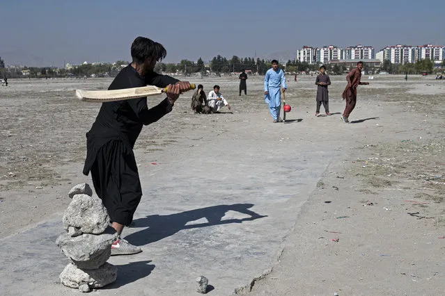 Afghan men play cricket at a field in the Chaman-e-Huzuri area of downtown Kabul on October 24, 2023. Fireworks and celebratory gunfire raked Kabul's skies as Afghans celebrated their stunning eight-wicket cricket World Cup defeat of Pakistan, a rare burst of public jubilation since the Taliban takeover. (Photo by Wakil Kohsar/AFP Photo)