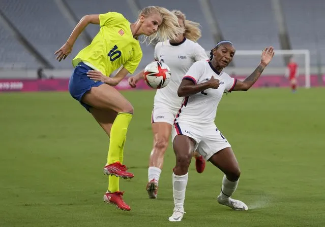 United States' Crystal Dunn, right, and Sweden's Sofia Jakobsson, left, fight for the ball during a women's soccer match at the 2020 Summer Olympics, Wednesday, July 21, 2021, in Tokyo. (Photo by Ricardo Mazalan/AP Photo)