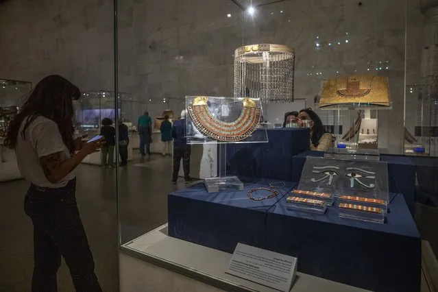 In this April 24, 2021 file photo, women look at a collection of the jewelry of Princess Neferuptah, the daughter of King Amenemhat III, on display in its glass case at the new National Museum of Egyptian Civilization in Old Cairo. As some European countries re-open to international tourists, Egypt has already been trying for months to attract them to its archaeological sites and museums. Officials are betting that the new ancient discoveries will set it apart on the mid- and post-pandemic tourism market. (Photo by Nariman El-Mofty/AP Photo/File)