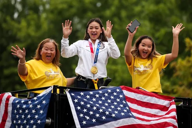 Olympic gold medalist Sunisa Lee, center, makes a heart sign for her fans during a parade in her honor in St. Paul, Minn. on Sunday, August 8, 2021. Lee, of St. Paul, took home three Olympic medals – gold, silver and bronze – in gymnastics from the 2020 Summer Olympics in Tokyo. She is joined by Her mother, Yeeb Thoj, left, and her sister, Shyenne Lee. (Photo by David Berding/USA TODAY Sports)