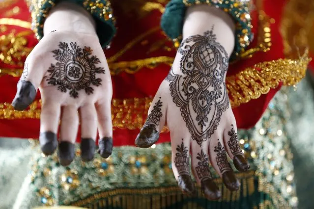 A model displays henna tattoo designs on her hands during a Henna tattoo competition in Banda Aceh, Indonesia, 07 November 2023. The tradition of coloring body parts is a ritual carried out by Acehnese Muslim women when they are about to get married, using henna leaves known as Lawsonia inermis. Henna has long been used as a cosmetic for coloring women's nails and hair. (Photo by Hotli Simanjuntak/EPA)