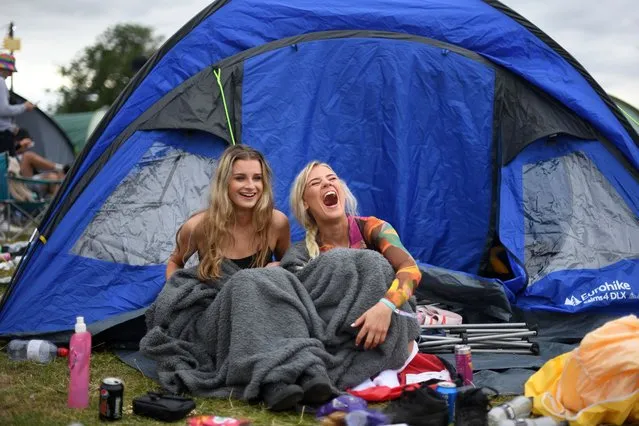 Festival-goers set up their tent as they attend Reading Festival in Reading, west of London, on August 27, 2021. As coronavirus covid-19 infection levels rise across the country, vaccines will be offered to revellers throughout the weekend. The organiser of Reading and Leeds Festivals has said such events are arguably “safer places to be” because attendees have been tested for covid-19. The festivals are returning this year with headliners including Stormzy, after being cancelled last year due to the pandemic. (Photo by Daniel Leal-Olivas/AFP Photo)
