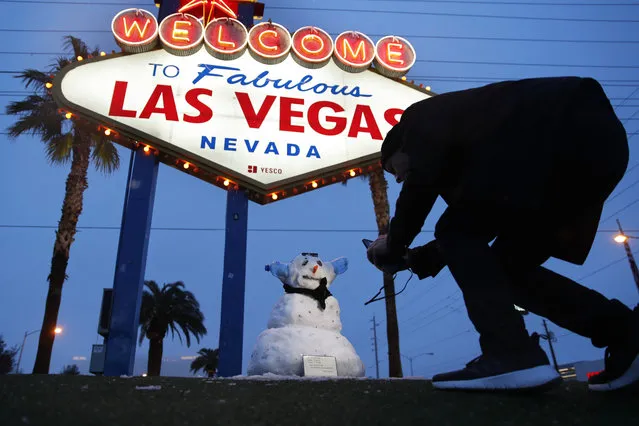 A man, who declined to give his name, takes a picture of a small snowman at the “Welcome to Fabulous Las Vegas” sign along the Las Vegas Strip, Thursday, February 21, 2019, in Las Vegas. Las Vegas is getting a rare taste of real winter weather, with significant snowfall across the metro area in the first event of its kind since record keeping started back in 1937. (Photo by John Locher/AP Photo)