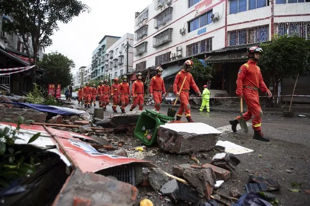 In this photo released by Xinhua News Agency, rescue workers walk near debris in the aftermath of an earthquake in Fuji Township of Luxian County in southwestern China's Sichuan Province, on Thursday, September 16, 2021.An earthquake collapsed homes, killed some and injured others Thursday in southwest China's Sichuan province, state media reported. (Photo by Jiang Hongjing/Xinhua via AP Photo)