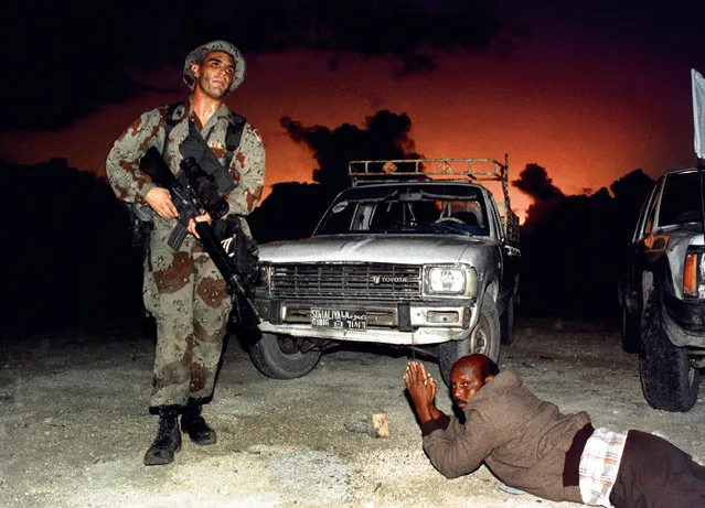 A Somali driver is ordered to lie on the ground as U.S. Marines establish security in the port of Mogadishu during an amphibious assault named Operation Restore Hope, in Somalia, December 9, 1992. (Photo by Yannis Behrakis/Reuters)