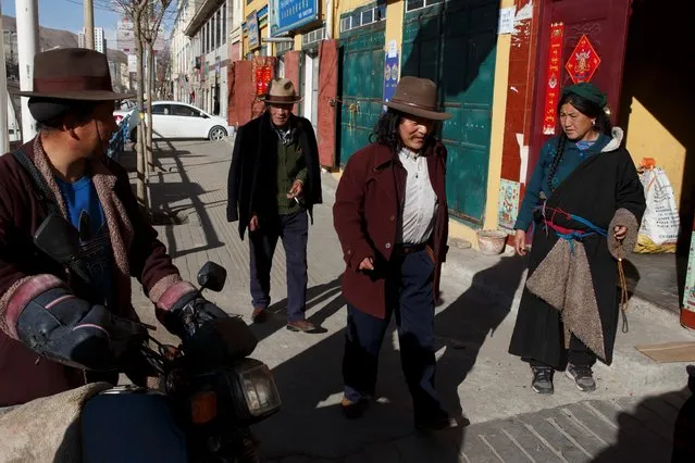 Tibetans walk in a street near Rongwo Monastery in the largely ethnic Tibetan town of Rebkong, Qinghai province, China on March 9, 2019. (Photo by Thomas Peter/Reuters)