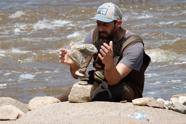 Tim Anderson, rock balancing “pro” from Pennsylvania, carefully works to balance his stack on a dry spot in the Llano river Saturday March 12, 2016. He was an honored guest of the festival and enjoyed visiting Texas so he came for another year. The river was higher this year because of the rains so the balancers could not get to the better rock that were available last year. (Photo by Nell Carroll/American-Statesman)