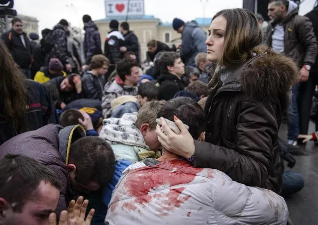 Wounded supporters of Ukraine's new government sit on the ground, in an area protected by the police, after clashes with pro-Russian protesters in central Kharkiv March 1, 2014. Pro-Russia activists clashed with supporters of the new Ukrainian government in the eastern Ukrainian city of Kharkiv on Saturday and tried to seize the regional governor's headquarters, Interfax news agency said. (Photo by Reuters/Stringer)