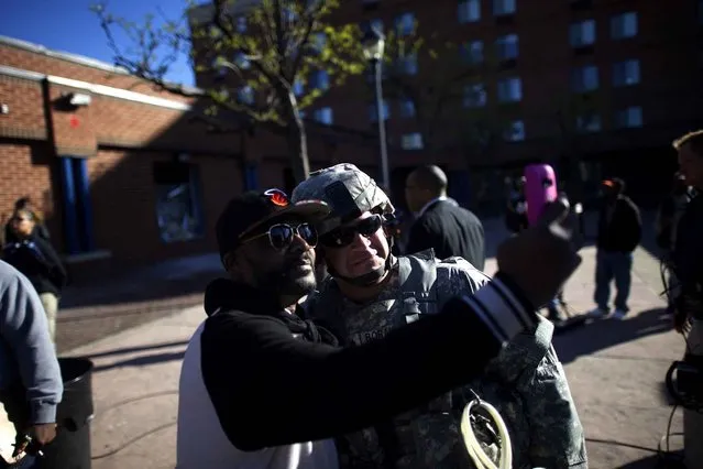 A National Guard soldier poses for a selfie the morning after citywide riots following the funeral of Freddie Gray, on April 28, 2015 in Baltimore, Maryland. (Photo by Mark Makela/AFP Photo)