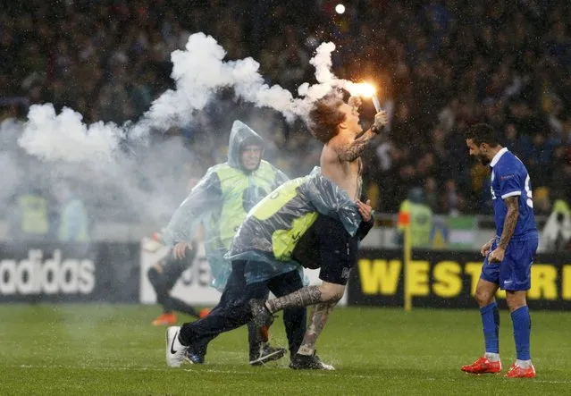A security attempts to stop a supporter of Dnipro Dnipropetrovsk who ran onto the pitch to celebrate the victory over Napoli in the Europa League semi-final second leg soccer match at the Olympic stadium in Kiev, Ukraine, May 14, 2015. (Photo by Valentyn Ogirenko/Reuters)