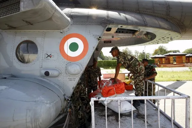 Nepalese army personnel load earthquake relief aid inside an Indian helicopter heading towards Sindhupalchok District, at Tribhuvan International Airport in Kathmandu May 14, 2015. (Photo by Navesh Chitrakar/Reuters)