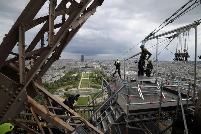 A person rides on a zip-line descending from the second floor of the Eiffel Tower on May 28, 2019 in Paris. The 800 meter crossing takes one minute at a speed of 90km/h. The zip-line will be opened from May 29 to June 2, 2019. (Photo by Francois Guillot/AFP Photo)