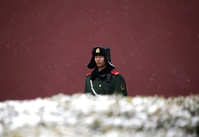 A paramilitary police officer stands guard during a snowfall near Tiananmen Square in Beijing, China February 21, 2017. (Photo by Jason Lee/Reuters)