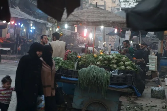 Women walk near displayed produce in a vegetable market in Aleppo's rebel-controlled Bustan al-Qasr neighbourhood, Syria April 6, 2016. (Photo by Abdalrhman Ismail/Reuters)