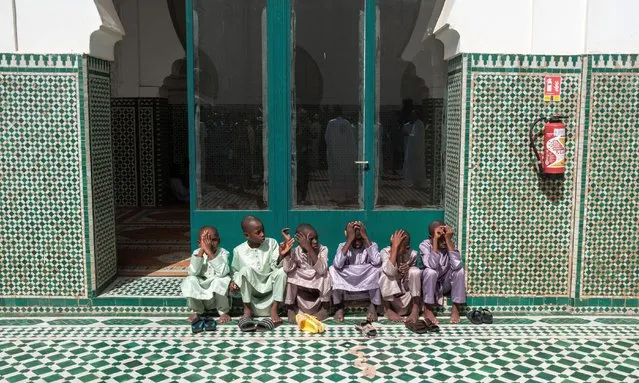 Young boys dressed in traditional clothes wait for a prayer to start the Eid al-Fitr festival, marking the end of the holy month of Ramadan, locally known as Korite, at the Dakar Grand Mosque in Dakar on April 10, 2024. (Photo by Guy Peterson/AFP Photo)