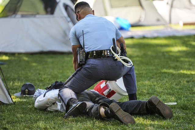 A Georgia State Patrol officer detains a protester on the campus of Emory University during a  pro-Palestinian demonstration Thursday, April 25, 2024, in Atlanta. (Photo by Mike Stewart/AP Photo)