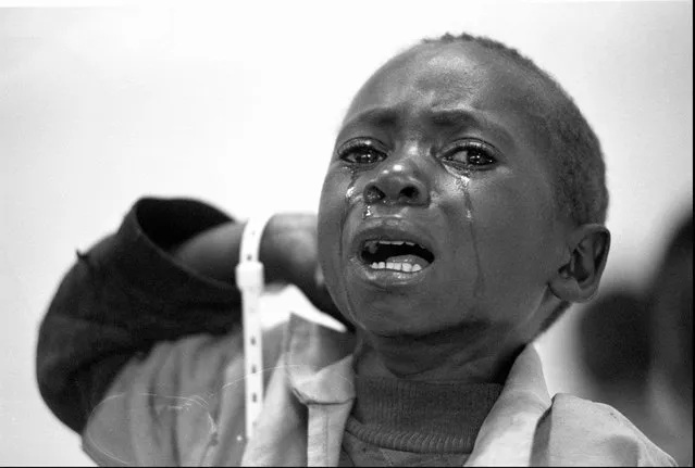 An unaccompanied child cries while waiting at a transit camp in Gisenyi, Rwanda; 1996. (Photo by Carol Guzy/The Washington Post)