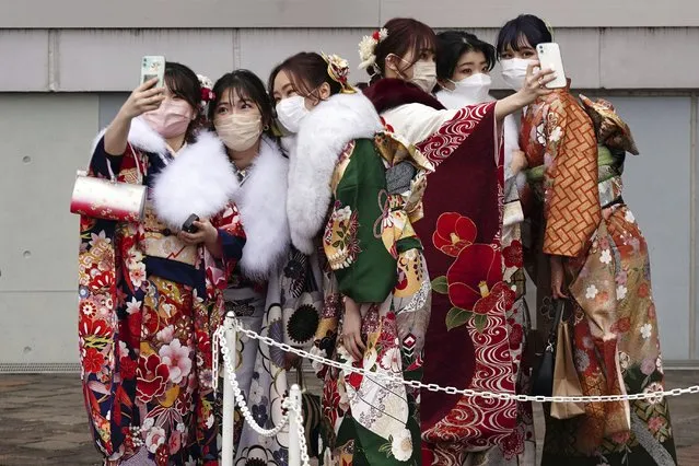 Kimono-clad women celebrating turning 20 years old take selfie together prior to attending a Coming-of-Age ceremony Monday, January 10, 2022, in Tokyo. Held annually on the second Monday of January, Coming of Age Day is a special time for those young adults. (Photo by Eugene Hoshiko/AP Photo)