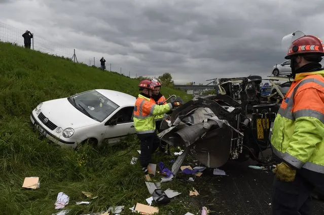 French rescue workers intervene on the site of a road accident on April 25, 2016 between two trucks and six other vehicles near Les Mureaux on the A13 motorway heading towards Paris, which caused at least two seriously injured. (Photo by Eric Feferberg/AFP Photo)