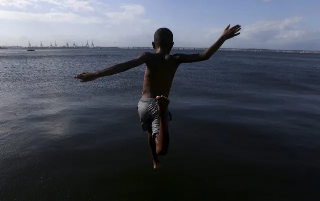 A child jumps into the waters of Guanabara Bay in Rio de Janeiro's downtown Brazil, January 5, 2016. (Photo by Ricardo Moraes/Reuters)