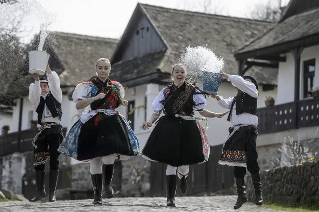 Dressed in folk costumes, young men pour water on young women in Holloko, a mountain village enlisted on the World Heritage List of Unesco, some 80 km northeast of Budapest, Hungary, 01 April 2021, during a press event. Holloko is famous for its traditional Easter celebrations but this year all the events have been cancelled due to the coronavirus. (Photo by Peter Komka/EPA/EFE)