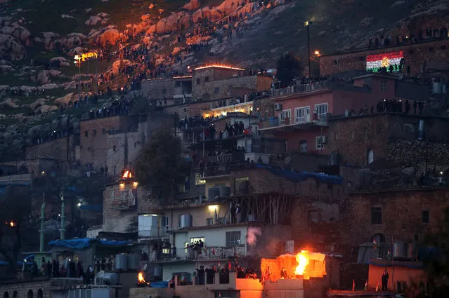 People light bonfires as they watch a torch procession up a hill during celebrations of the Kurdish New Year Newroz in Akre, Aqrah, Kurdistan Region, northern Iraq, 20 March 2017. (Photo by Gailan Haji/EPA)
