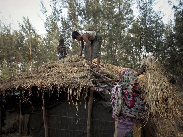 60 year old Mukluhammad, 25 year old Zahad Hossain, and 45 year old Dilchar build a roof on their new home in the Shamalapur Rohingya refugee settlement in Chittagong district. (Photo by Getty Images/Stringer)