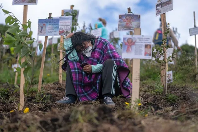 A mourner reacts as a tree is planted with the ashes of a victim lost to Covid-19 at the Paramo de Guerrero nature preserve near Cogua, Colombia, on Sunday, June 27, 2021. Protest-wracked Colombia surpassed 104,000 deaths from Covid-19 as the government tries to balance reopening large swathes of the economy with protecting citizens from the pandemic. (Photo by Nathalia Angarita/Bloomberg via Getty Images)