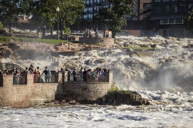 Many families embark on Falls Park in Sioux Falls, S.D., as water rose quickly Saturday, June 22, 2024, after days of heavy rain led to flooding in the area. (Photo by Josh Jurgens/AP Photo)