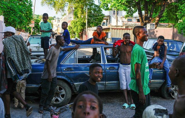 Youth hang out near cars serving as street barricades placed there by residents to deter gangs from entering their neighborhood, in downtown Port-au-Prince, Haiti, Friday, May 17, 2024. (Photo by Ramon Espinosa/AP Photo)