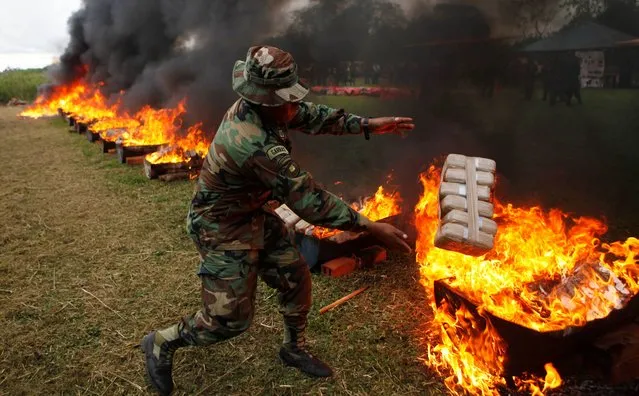 Anti-narcotics police agents incinerate seized packages of cocaine, in Trinidad, Bolivia, Wednesday, May 14, 2014. Anti-drug police burned over 1500 kilograms of drugs seized during last week's operations on the eastern region Beni, according to Police Colonel Mario Centellas, director of Bolivia's special forces against drug trafficking. (Photo by Juan Karita/AP Photo)