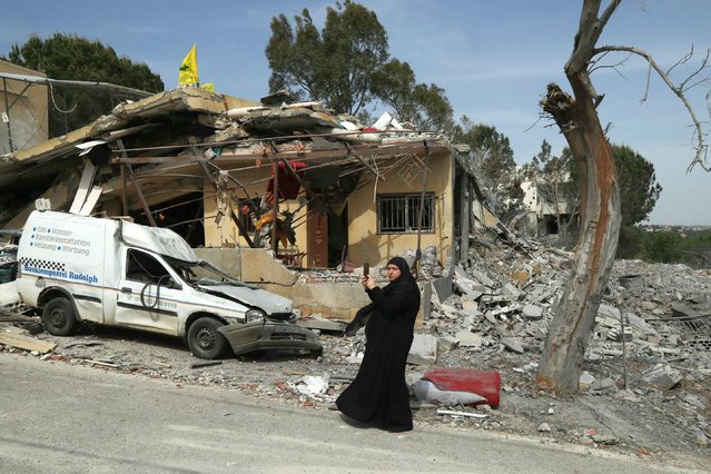 A woman stands in front of the house where two women from the same family were killed on April 23 in a reported Israeli strike in the southern Lebanese village of Hanin, on April 25, 2024. Lebanon's Iran-backed Hezbollah movement said it fired a fresh barrage of rockets across the border on April 24 after a strike blamed on Israel killed the two civilians. (Photo by Hassan Fneich/AFP Photo)