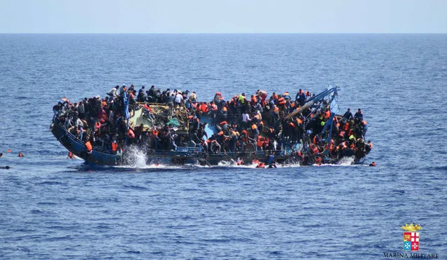 People jump out of a boat right before it overturns off the Libyan coast, Wednesday, May 25, 2016. The Italian navy says it has recovered 7 bodies from the overturned migrant ship off the coast of Libya. Another 500 migrants who on board were rescued safely. (Photo by Marina Militare via AP Photo)