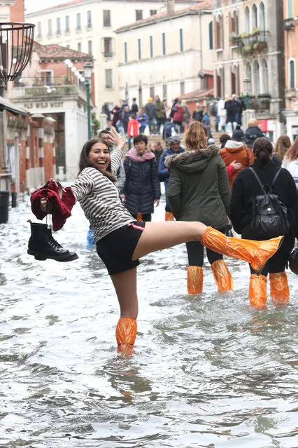 Tourists and residents wade through high water in Venice, Italy, 17 November 2019. High tidal waters returned to Venice on a day earlier, four days after the city experienced its worst flooding in more than 50 years. (Photo by Emiliano Crespi/EPA/EFE)