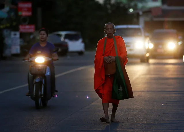 A Buddhist monk walks along a street to receive food from people in Nonthaburi province, on the outskirts of Bangkok, Thailand February 8, 2017. (Photo by Chaiwat Subprasom/Reuters)