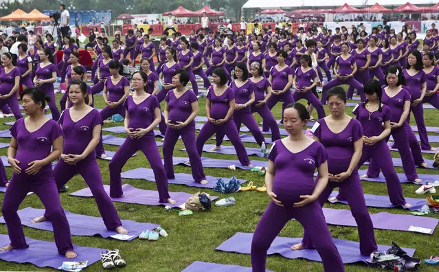 Pregnant women practice yoga as they attempt to break the Guinness World Record for the largest prenatal yoga class, in Changsha, Hunan province June 8, 2014. A total of 505 pregnant women participated in a yoga class together for 37 minutes and 28 seconds on Sunday, exceeding the current Guinness World Record set in Shenzhen in 2013 with 423 women, local media reported. (Photo by Reuters/China Daily)