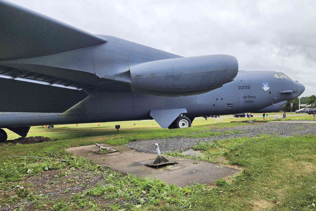 This photo, provided by CAP Media, shows the B-52 that is on display outside of the Griffiss Business Park that was blown off its moorings, foreground, by a tornado, in Rome, N.Y., Tuesday, July 16, 2024. Much of the U.S. and Canada is cleaning up or still dealing with a new wave of severe storms that have caused deaths and damage this week from the Plains to New England. (Photo by Courtesy CAP Media via AP Photo)