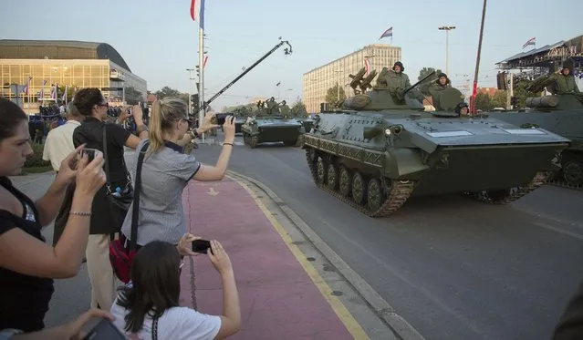 Attendants take photographs of military vehicles during a military parade marking the 20th anniversary of the “Operation Storm” that crushed Serb insurgency in Croatia, in Zagreb, Tuesday, August 4, 2015. (Photo by Darko Bandic/AP Photo)