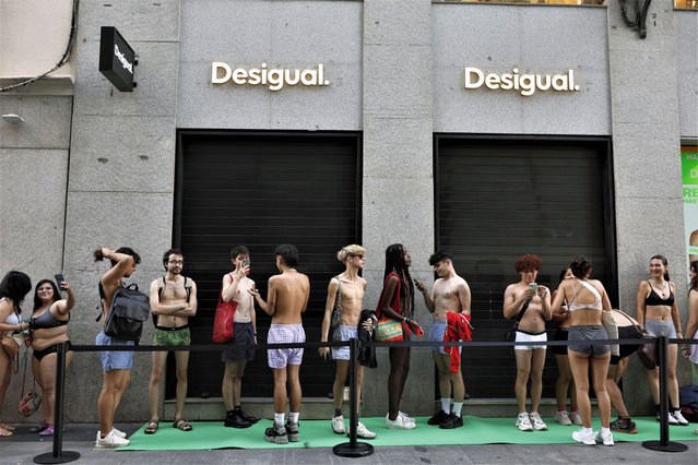 People dressed in their underware queue up at a Desigual store in Madrid, Spain on June 22, 2023. Two Desigual stores announced they would give away two pieces of clothing to the first 100 clients who showed up in their under wear, on occasion of the first day of summer sales. (Photo by Rodrigo Jimenez/EPA/EFE)