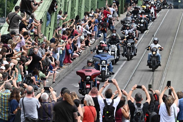 Motorbike enthusiasts ride their motorcycles across Liberty Bridge in downtown Budapest on June 24, 2023. Around 6000 motorcyclists took part in what is said to be the largest motorcycle parade in the history of the Hungarian capital, as the Harley Davidson company celebrates its 120th anniversary with a four-day festival in Hungary.  (Photo by Attila Kisbenedek/AFP Photo)