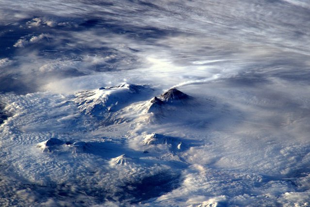 Tim Peake took this photo with the caption, “Spotted volcano smoking away on Russia's far east coast this morning – heat has melted snow around top”. (Photo by Tim Peake/ESA/NASA)