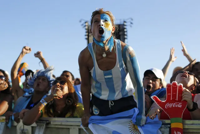 Argentina soccer fans shout as they watch a live telecast of the final World Cup match between Argentina and Germany inside the FIFA Fan Fest area on Copacabana beach in Rio de Janeiro, Brazil, Sunday, July 13, 2014. (Photo by Silvia Izquierdo/AP Photo)