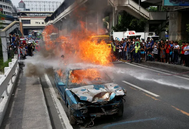 A car burns to simulate an earthquake aftermath, during a metrowide earthquake drill along main highway EDSA in Makati, Metro Manila, Philippines June 22, 2016. (Photo by Erik De Castro/Reuters)