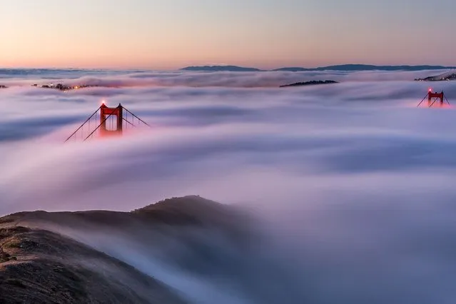 Thick early morning fog engulfed a huge world famous bridge so that only the very tip of it is visible above the clouds. (Photo by Solent News and Photo Agency)