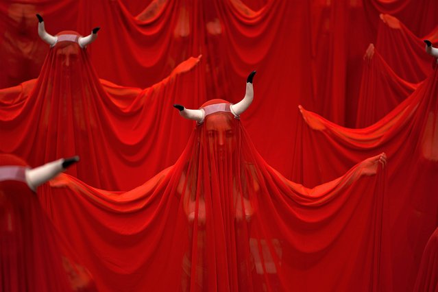 People covered with San Fermin's red color protest against animal cruelty before the start of the San Fermin festival at Plaza del Ayuntamiento square in Pamplona, northern Spain, Wednesday, July 5, 2023. On July 6th, the San Fermin festival will begin and last for nine days where thousands of people will take part in the famous running of the bulls through the old streets of the city. (Photo by Alvaro Barrientos/AP Photo)