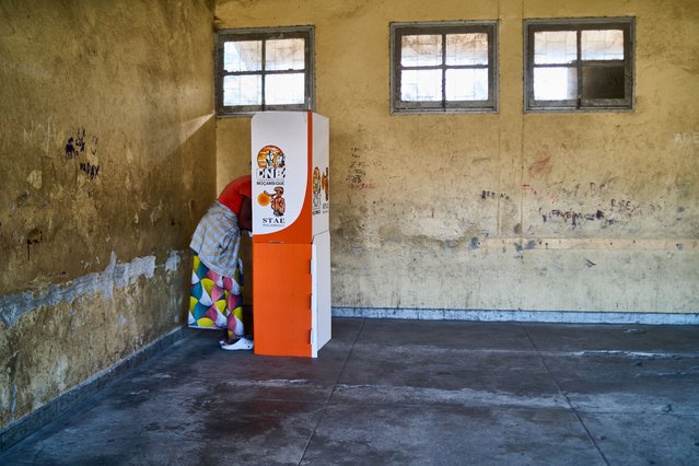 A voter marks her ballot in a voting booth at a polling station in Munhava in Beira on October 9, 2024 before polls open in Mozambique's national election. (Photo by Zinyange Aunton/AFP Photo)