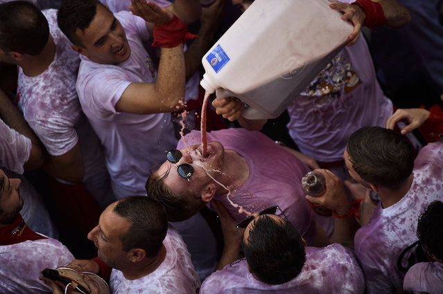 People celebrate during the launch of the “Chupinazo” rocket, to celebrate the official opening of the 2016 San Fermin Fiestas, in Pamplona, northern Spain, Wednesday, July 6, 2016. Revelers from around the world kick off the festival with a messy party in the Pamplona town square, one day before the first of eight days of the running of the bulls. (Photo by Alvaro Barrientos/AP Photo)