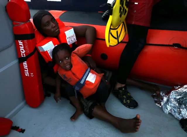 A child reacts as lifeguards of the Spanish NGO Proactiva Open Arms are transporting refugees and migrants onboard a RHIB in central Mediterranean Sea August 17, 2017. Over two hundred migrants and refugees, rescued on Thursday by the MOAS NGO, were transferred to a Proactiva vessel off the Libyan coast to be taken to Trapani port in Sicily. (Photo by Yannis Behrakis/Reuters)