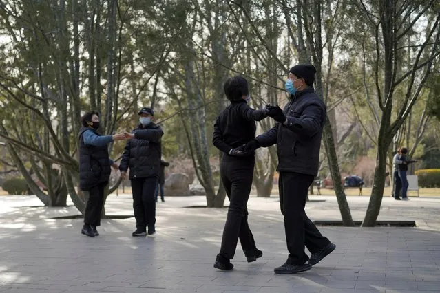 People wearing face masks dance at a park in Beijing, China on February 21, 2020. (Photo by Reuters/China Stringer Network)